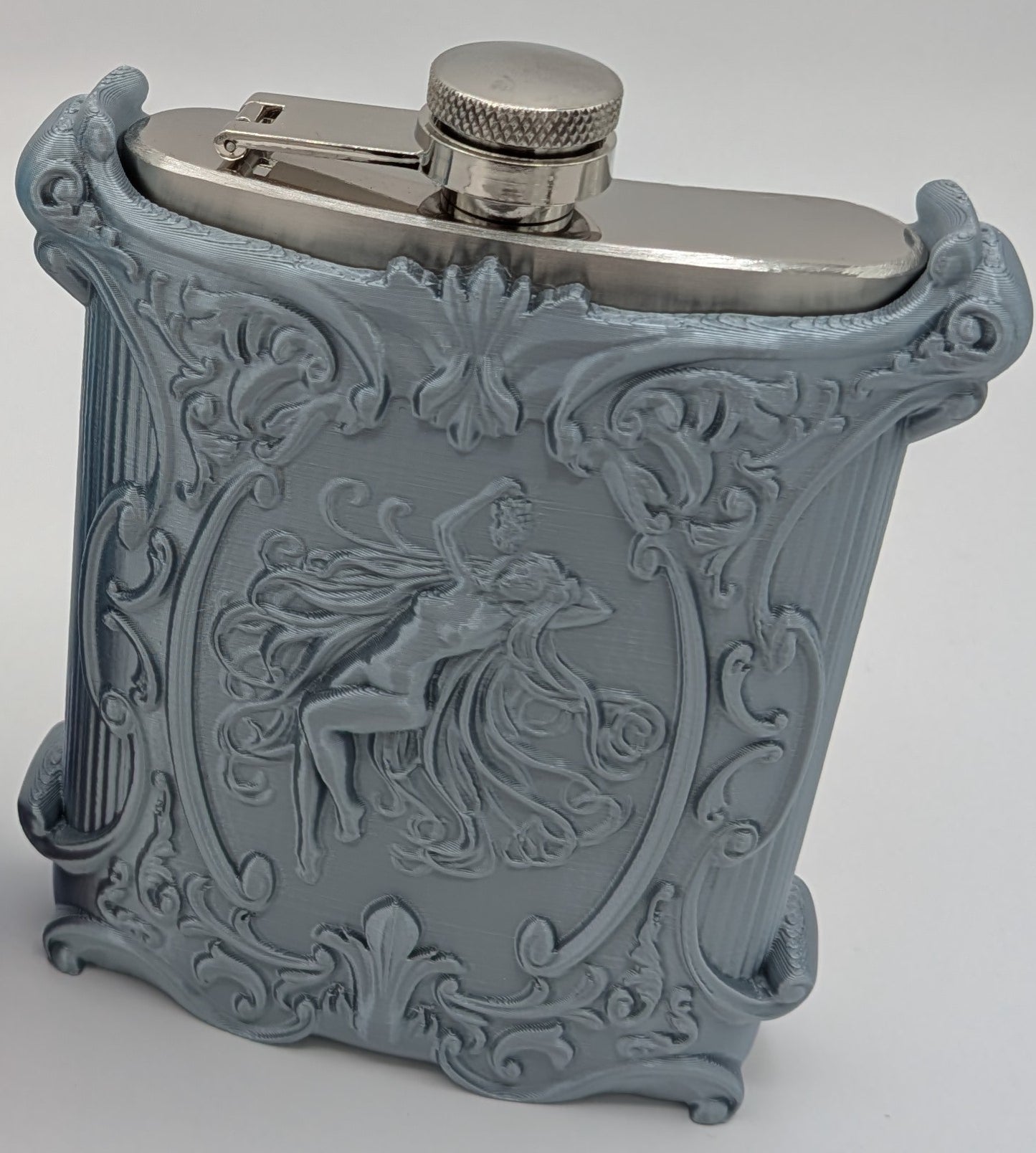 Elegant blue flask with ornate design and detailed engraving showcasing a graceful figure, perfect for stylish drink lovers.