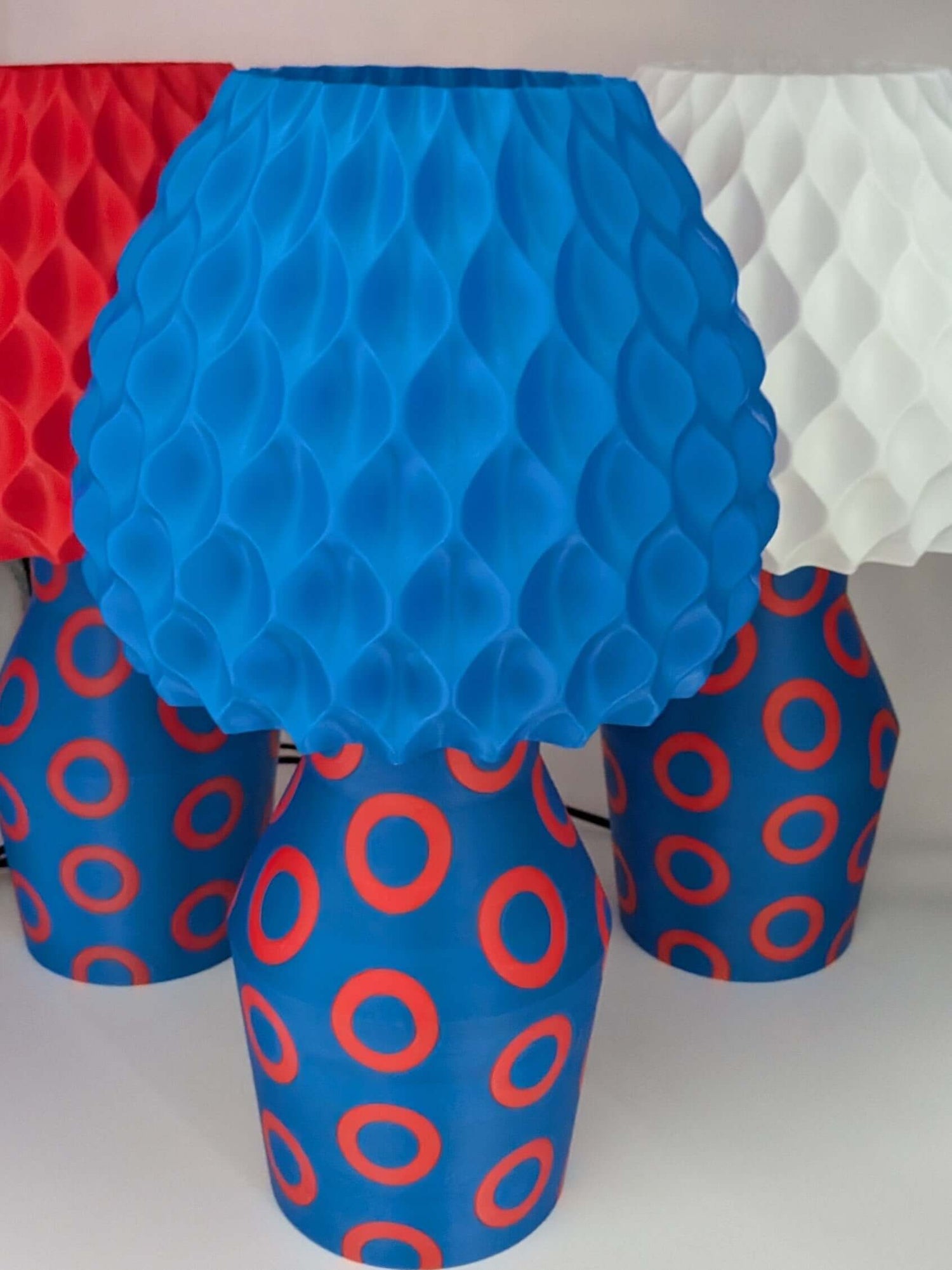 Phishy Donut Lamp with vibrant blue shade and red circle pattern, inspired by the energy of Phish, illuminating a room.